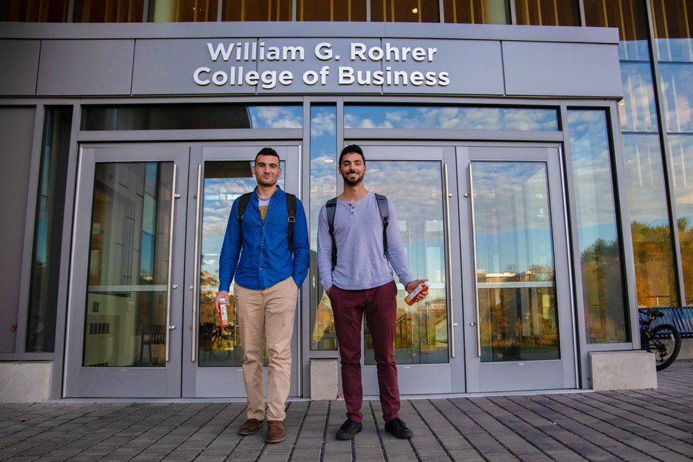 2 students standing outside of Business Hall